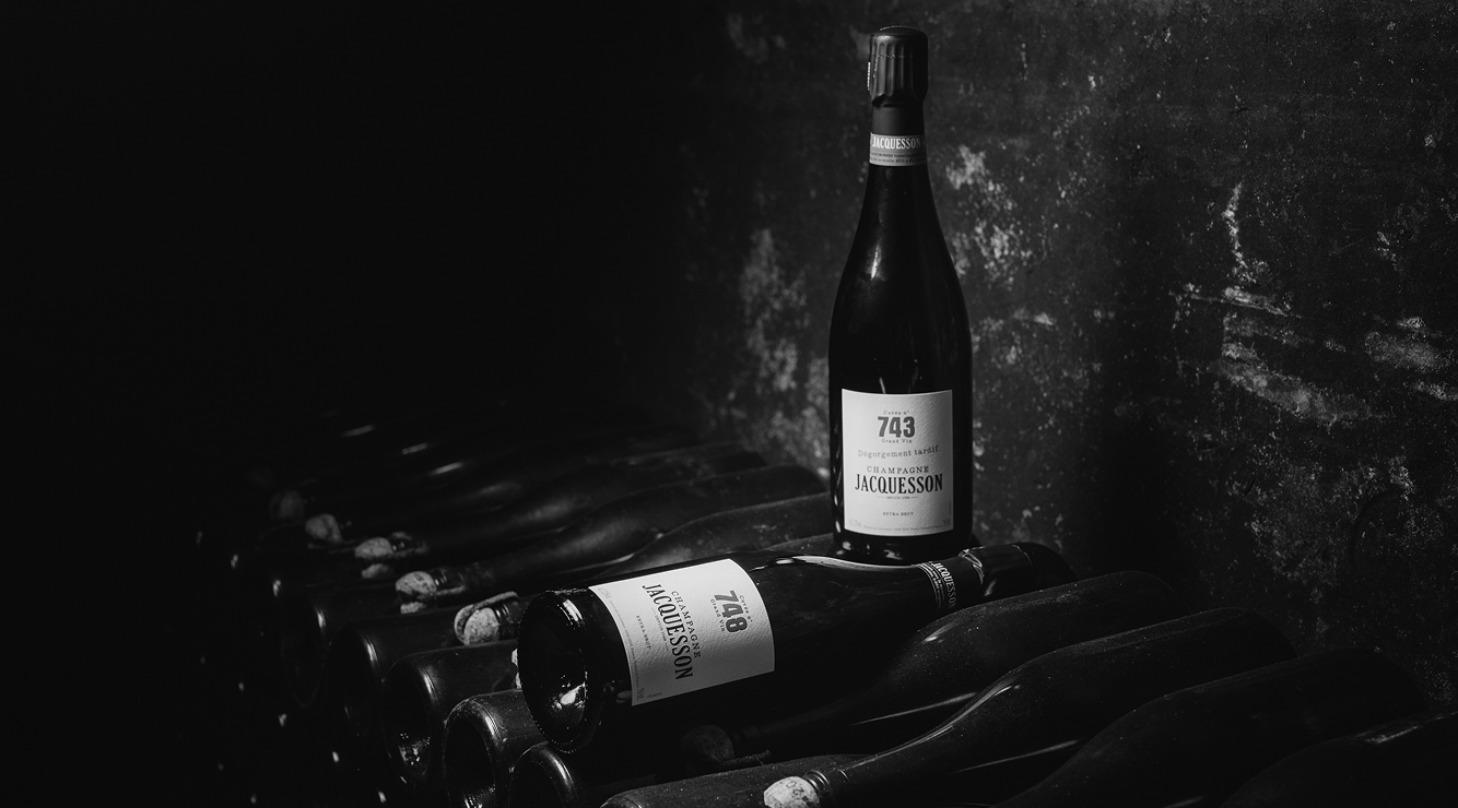 Bouteille de Champagne Jacquesson Cuvée 743 posée sur des bouteilles couchées dans la cave